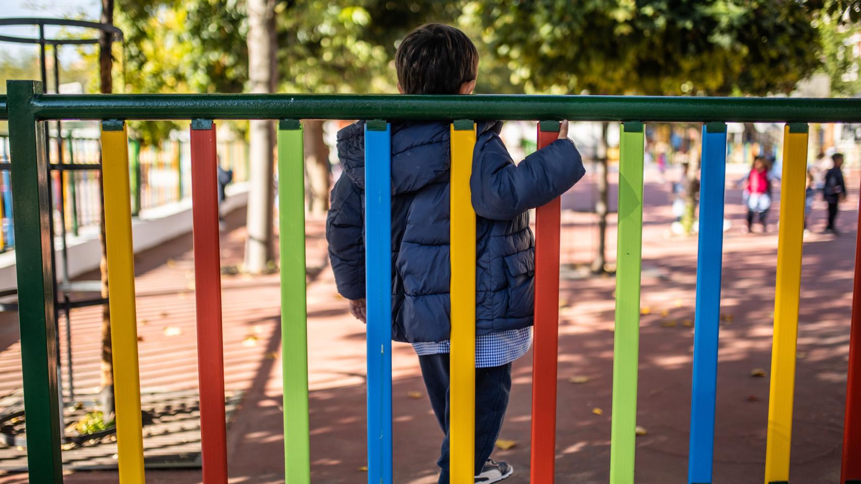 Un niño, en el patio de un colegio.