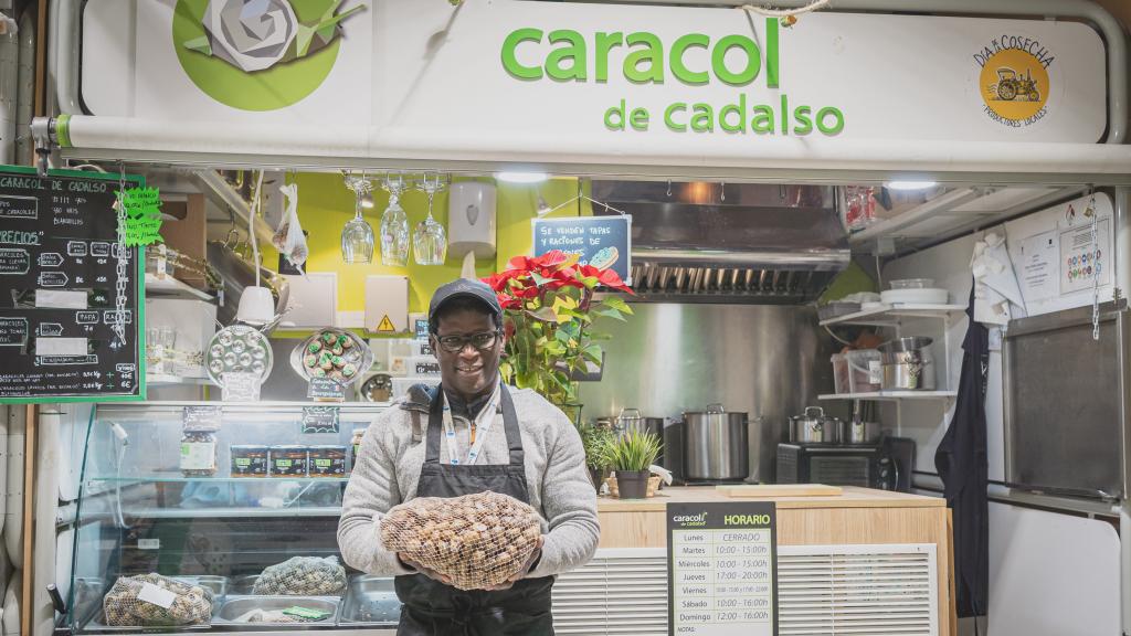 Ousmane Faye pesando caracoles en el puesto de mercado.
