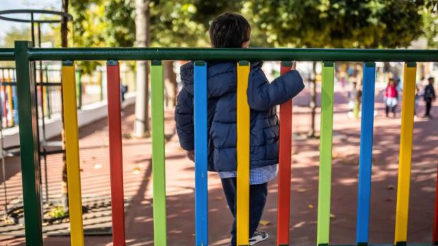 Un niño en el patio de un colegio.