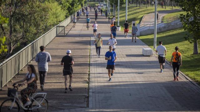 Varias personas caminando y corriendo por la calle.
