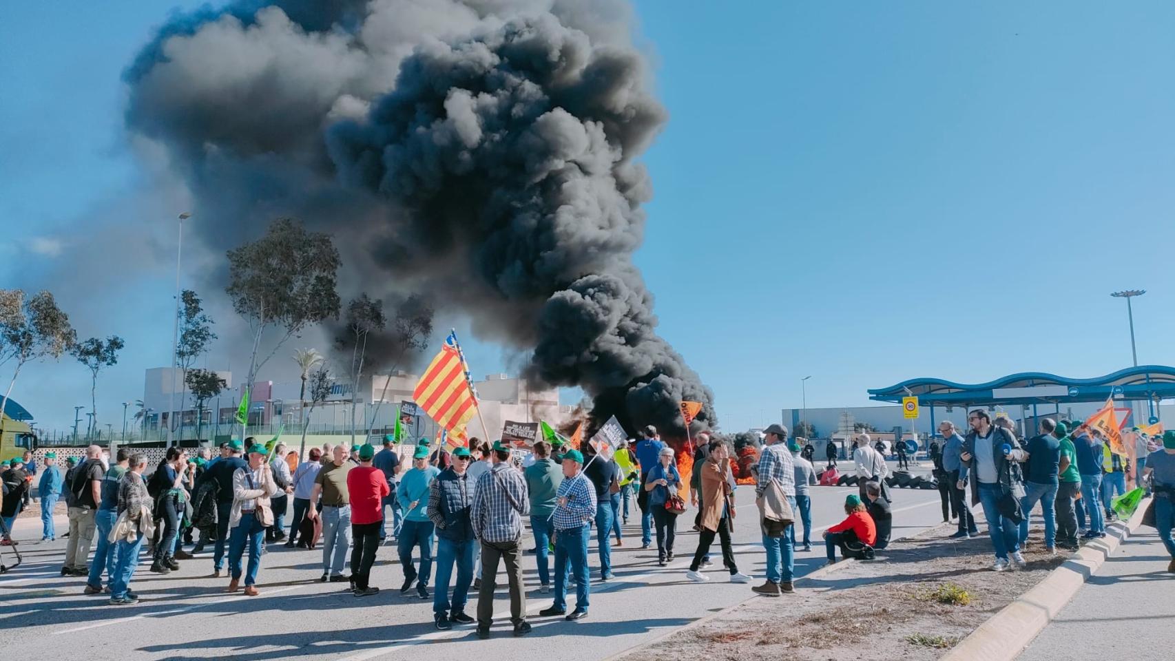 Unos agricultores cortan el acceso al Puerto de Castellón con una barricada de neumáticos.