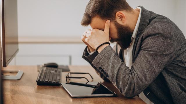 Hombre agobiado en su puesto de trabajo.