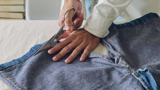 Imagen de archivo de una persona cortando unos vaqueros (Recovo).