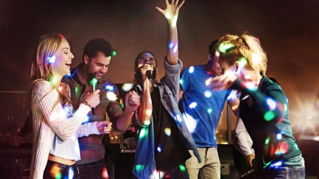 Un grupo de amigos canta en un karaoke.