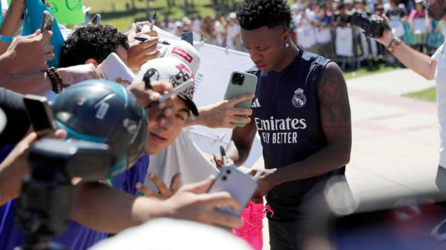 Vinicius firmando una camiseta a unos aficionados