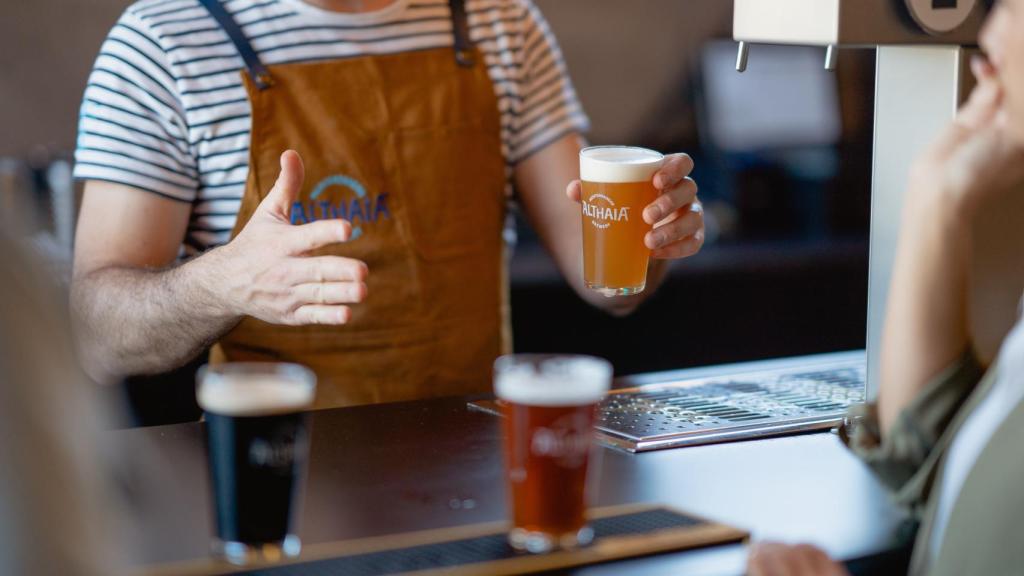 Un camarero sirviendo una cerveza.
