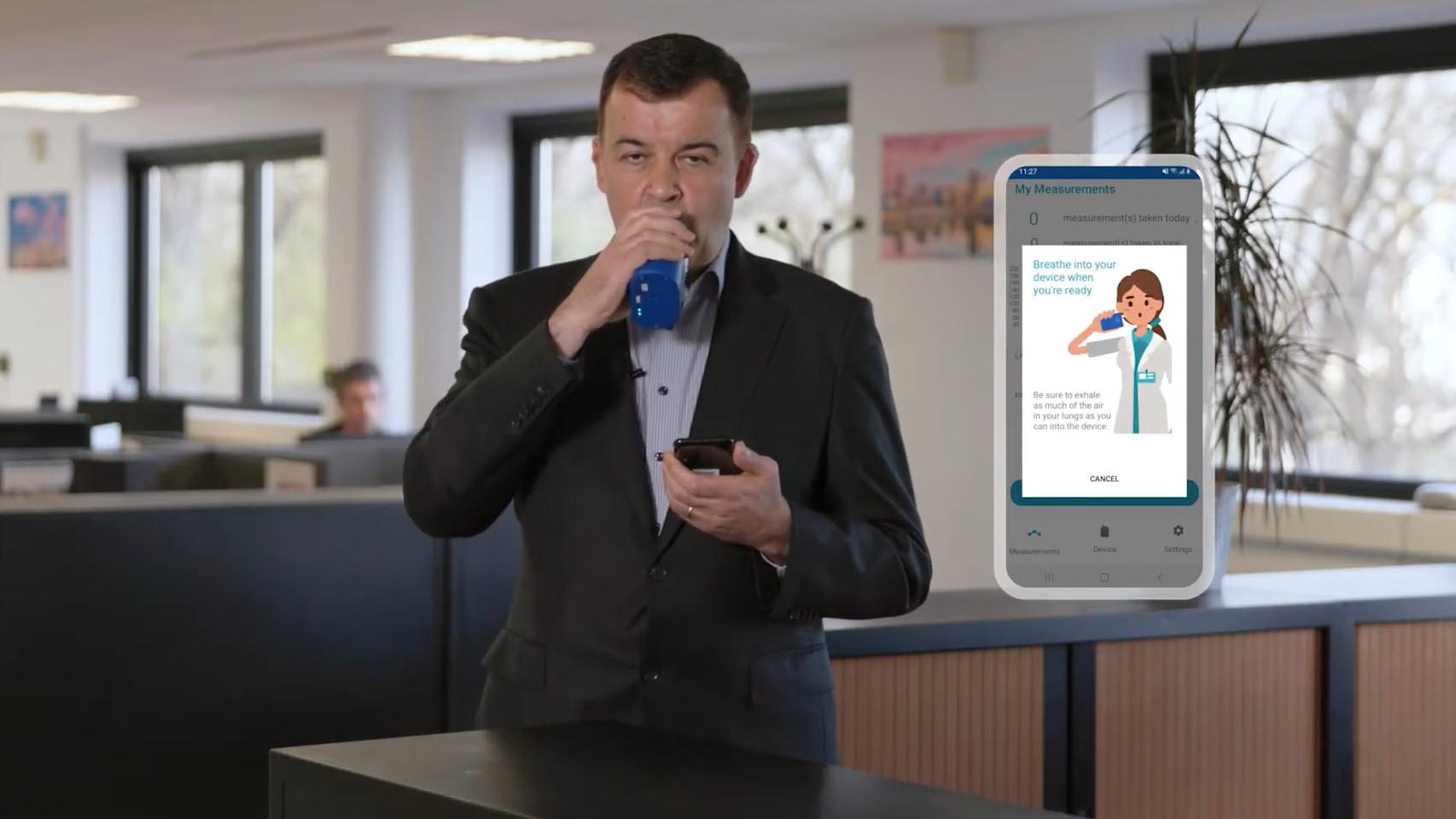 Una persona usando el dispositivo BOYDSense para medir la diabetes con el aliento.