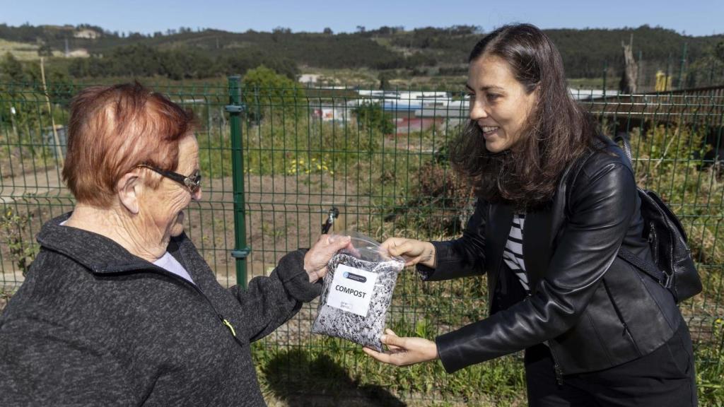 Noemí Díaz entrega compost a una vecina de Novo Mesoiro