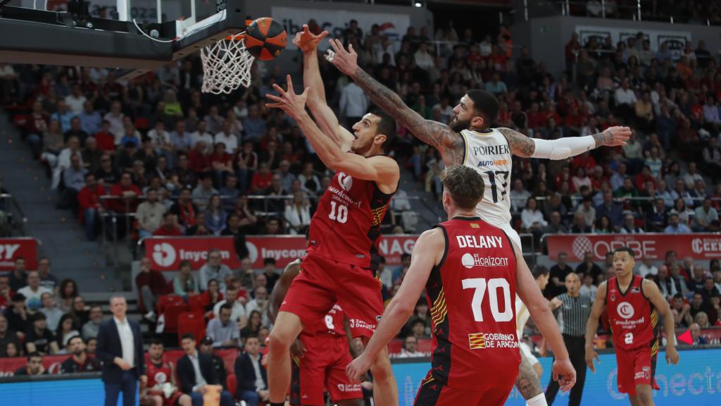 El pívot del Real Madrid Vincent Poirier (d) intenta taponar a Dejan Kravic, del Casademont Zaragoza.