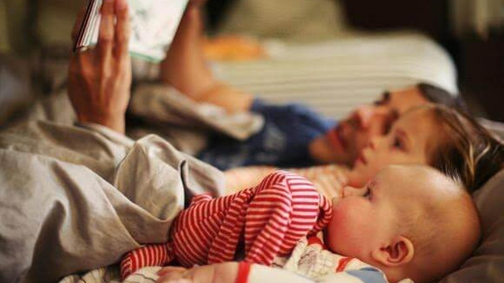 Un padre lee un cuento a sus hijos.