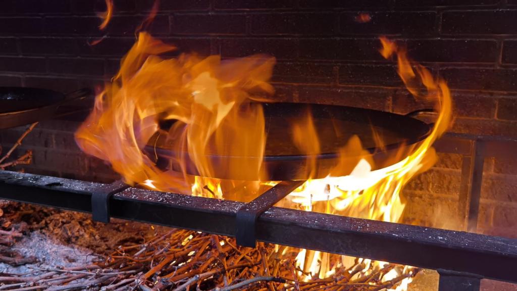 El sarmiento alimenta al fuego con el que preparan en La Llar los arroces.