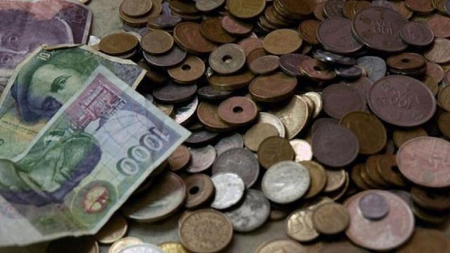 Varios billetes de mil pesetas junto a otras monedas