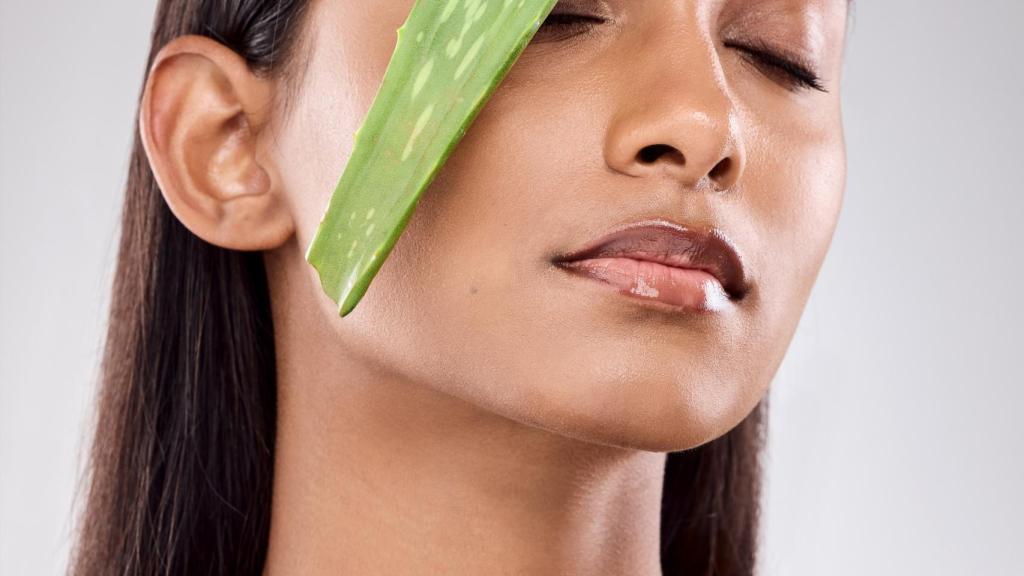 Mujer sosteniendo una hoja de aloe vera.