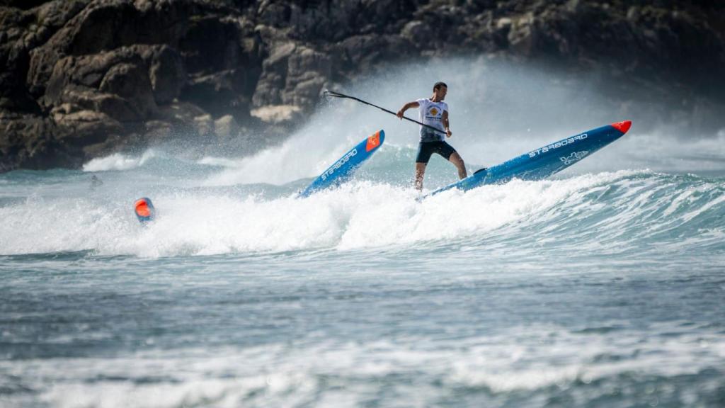 Un deportista cogiendo una ola