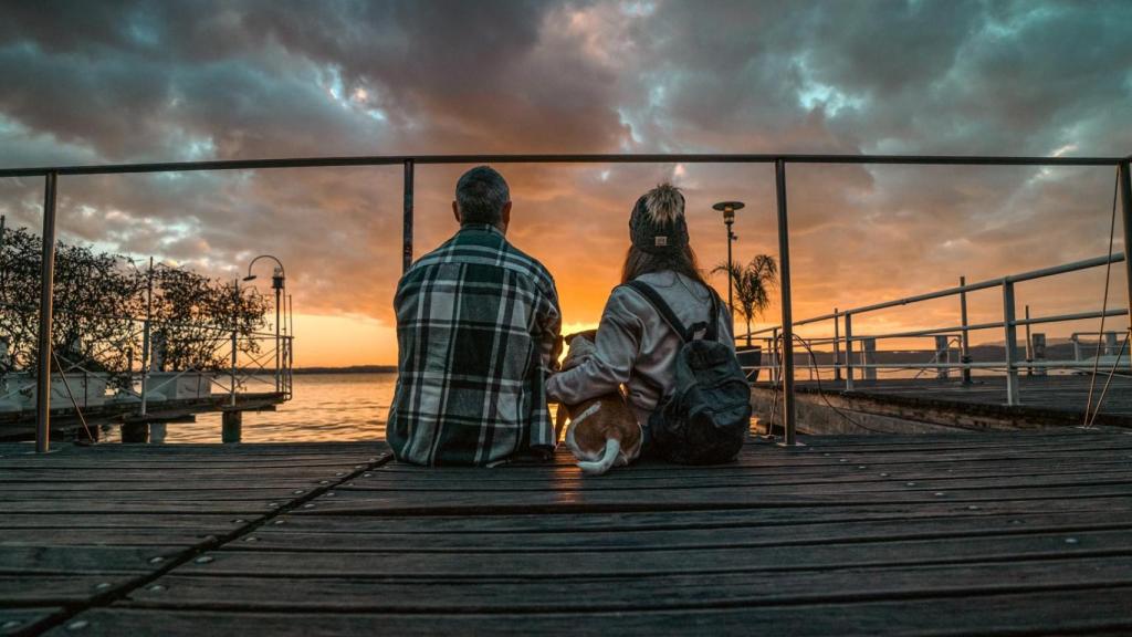 Daniel Acosta y Nayla Mesa frente a la puesta de sol junto a su perro Trufa.