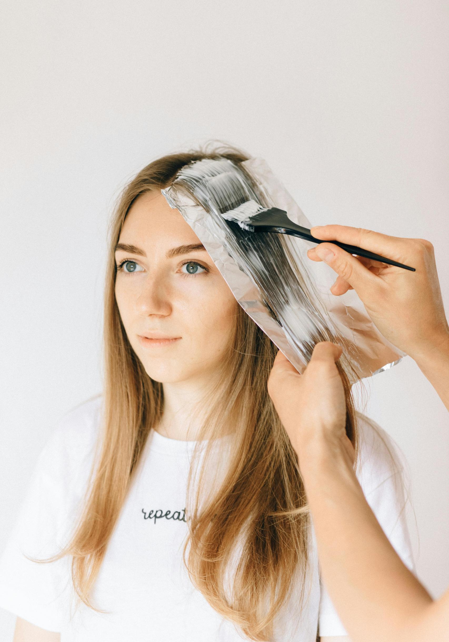 Mujer rubia en la peluquería repasando sus mechas