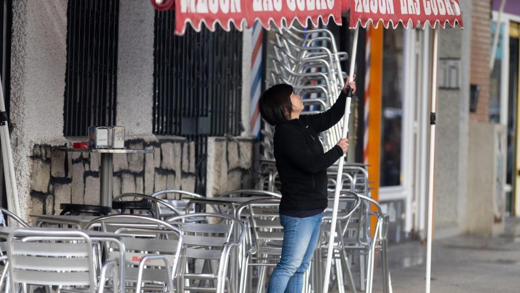 Una camarera levanta el toldo en un bar, en una imagen de archivo.