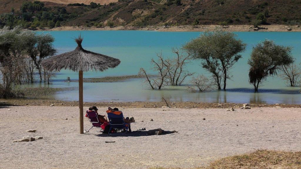 Personas bajo una sombrilla en la bahía de Lerate.