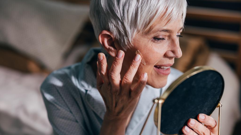 Una mujer mirándose en el espejo.