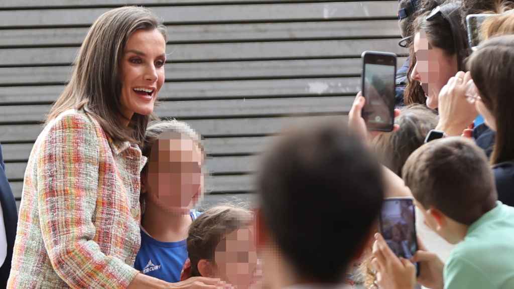 La Reina, rodeada de jóvenes a su llegada.