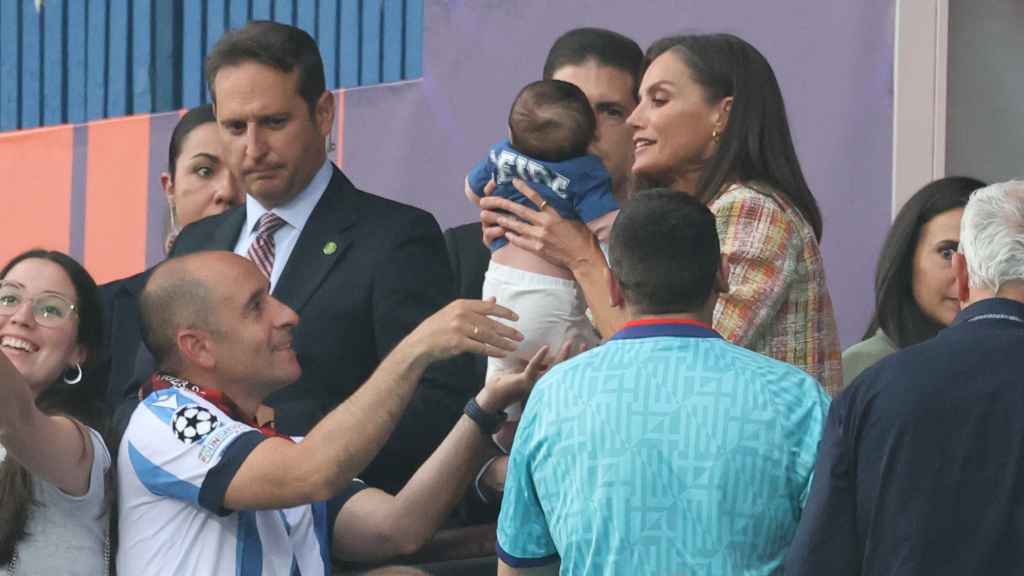 La Reina, cogiendo en brazos a un pequeño aficionado de la Real Sociedad.