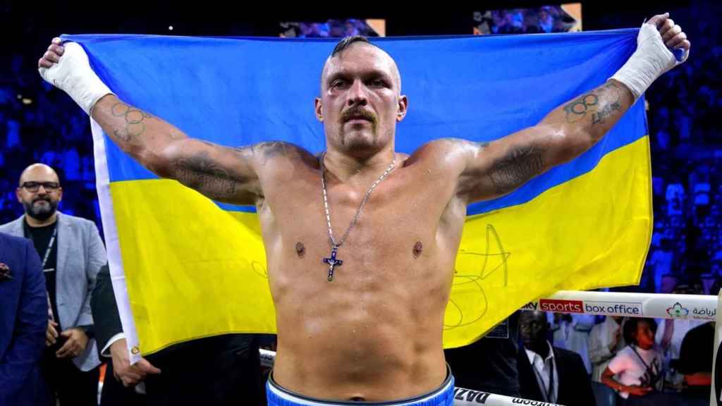 Oleksander Usyk celebra un triunfo con la bandera de Ucrania.