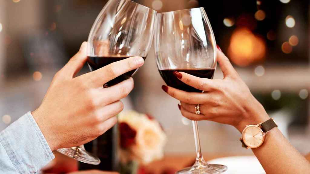 Dos personas brindando en una imagen de archivo.