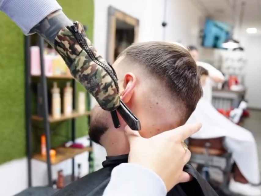 El barbero Francis De la Calle usando su guante para trabajar.