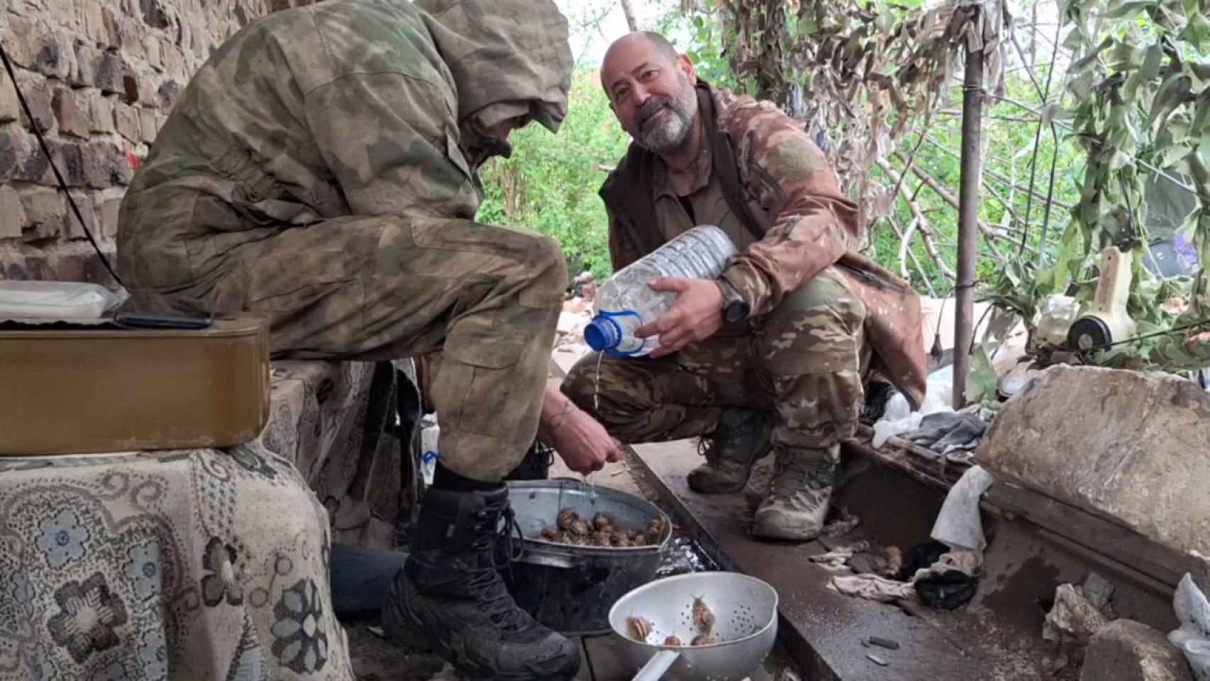 El valenciano Juan Manuel Soria, alias Simón de Monfort, a la derecha, prueba los caracoles que cocina para sus camaradas rusos en la posición defensiva.