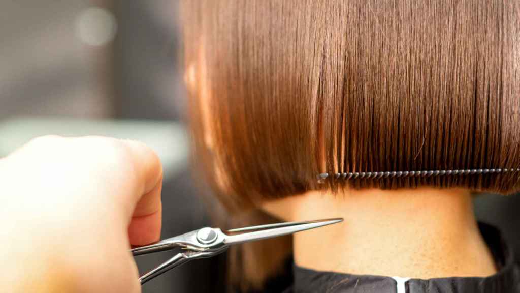 Mujer cortándose el cabello.