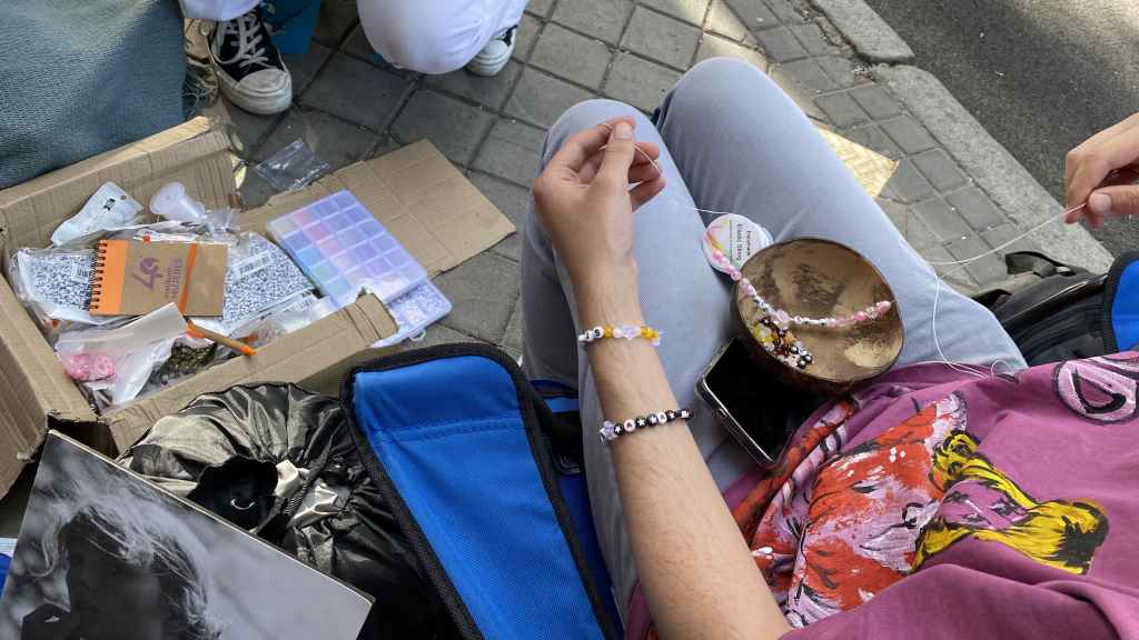 Emely, Carmen y Alejandro pasan el día conversando y haciendo pulseras.