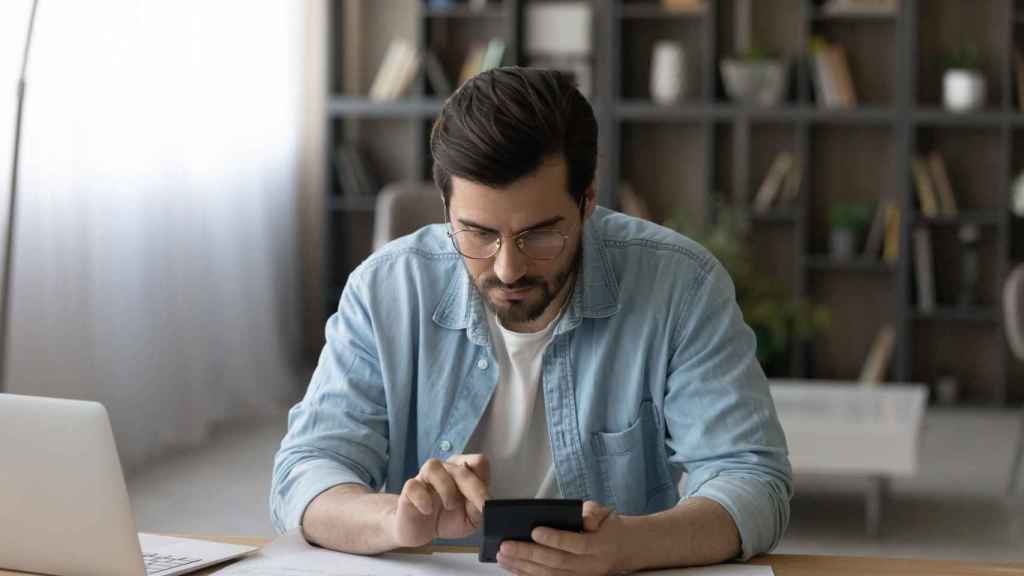 Un hombre simula hacer la declaración de la renta con su ordenador.