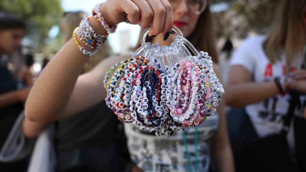 Una fan sostiene una colección de pulseras de Taylor Swift antes de su concierto en Lisboa (Portugal),