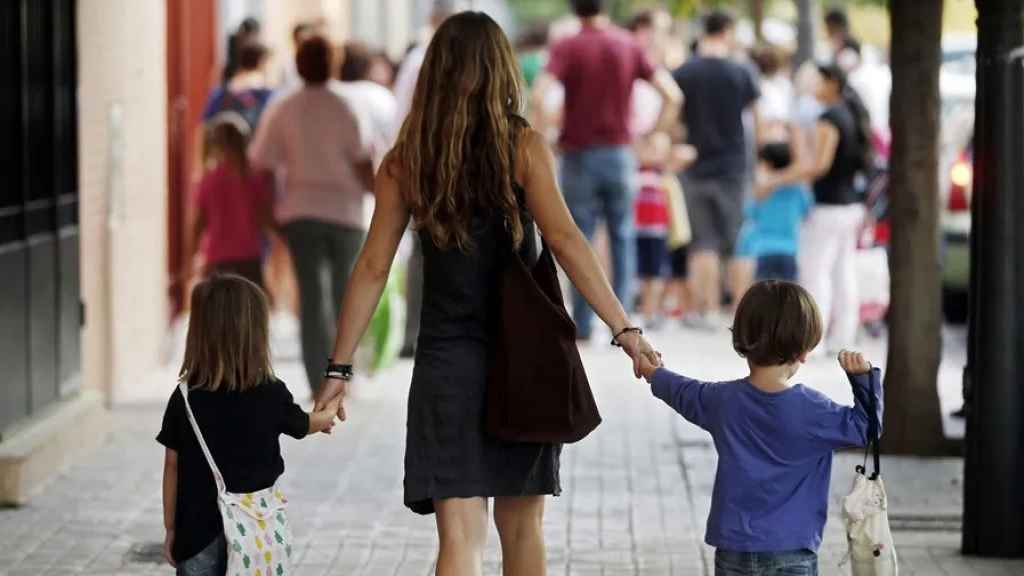 Una madre se dirige con sus hijos al colegio en una imagen de archivo