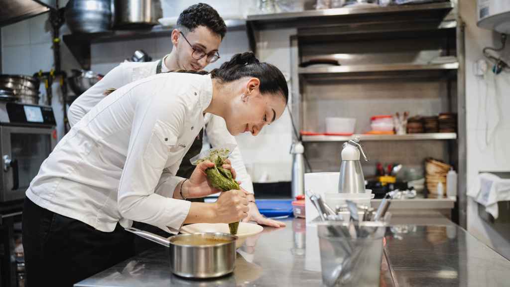 Los chefs Lucía y Sergio preparando un plato en la cocina de Lur.