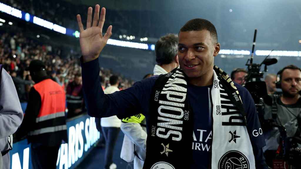 Kylian Mbappé saluda a unos aficionados.