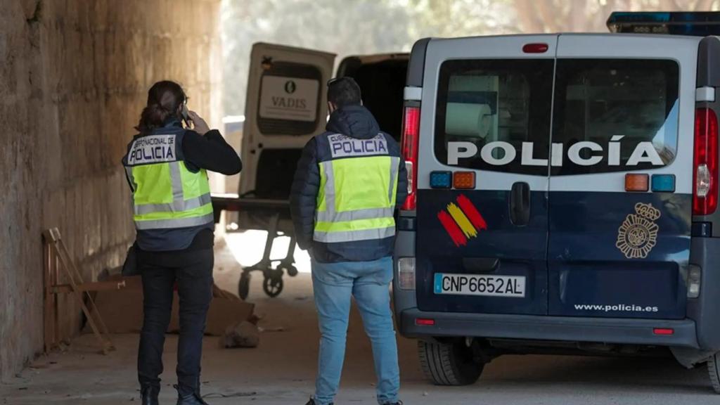 Dos agentes de la Policía Nacional aguardan bajo el Puente del Real, el lugar donde se halló a un fallecido.