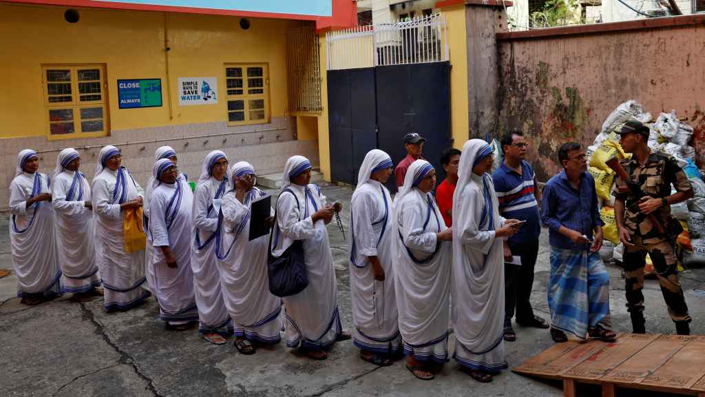 La gente espera afuera de un colegio electoral para votar durante la séptima y última fase de las elecciones generales de la India en Calcuta, India.