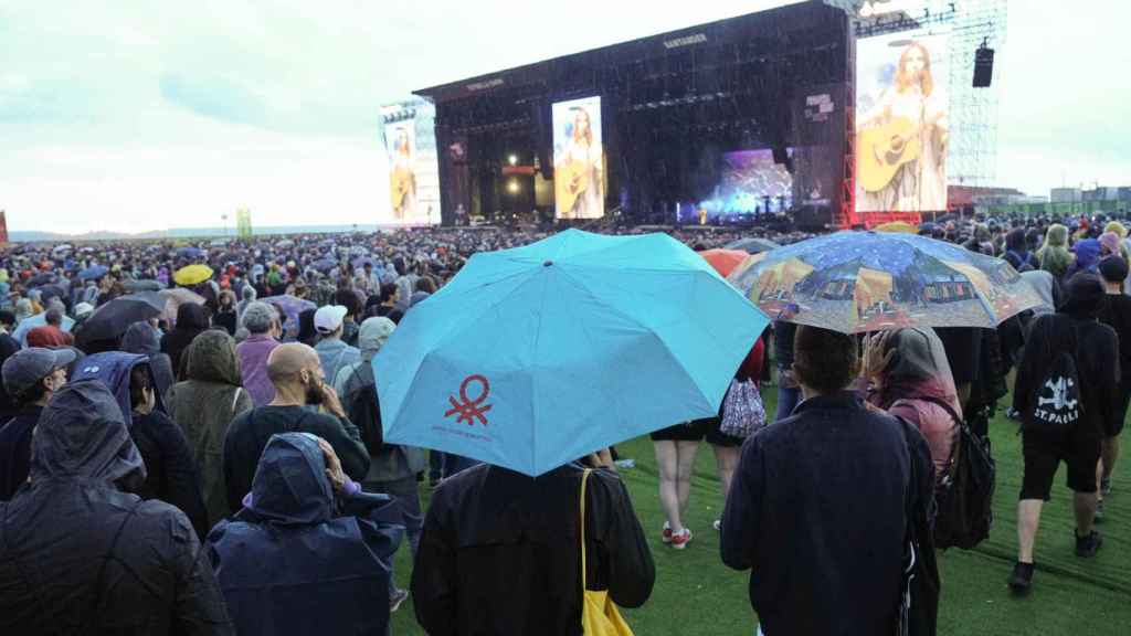 Asistentes al concierto de la cantante británica Pj Harvey se resguardan de la lluvia durante el concierto que ha ofrecido hoy sábado en la tercera jornada del Festival Primavera Sound que se celebra en Barcelona. Foto: EFE/Alejandro García.