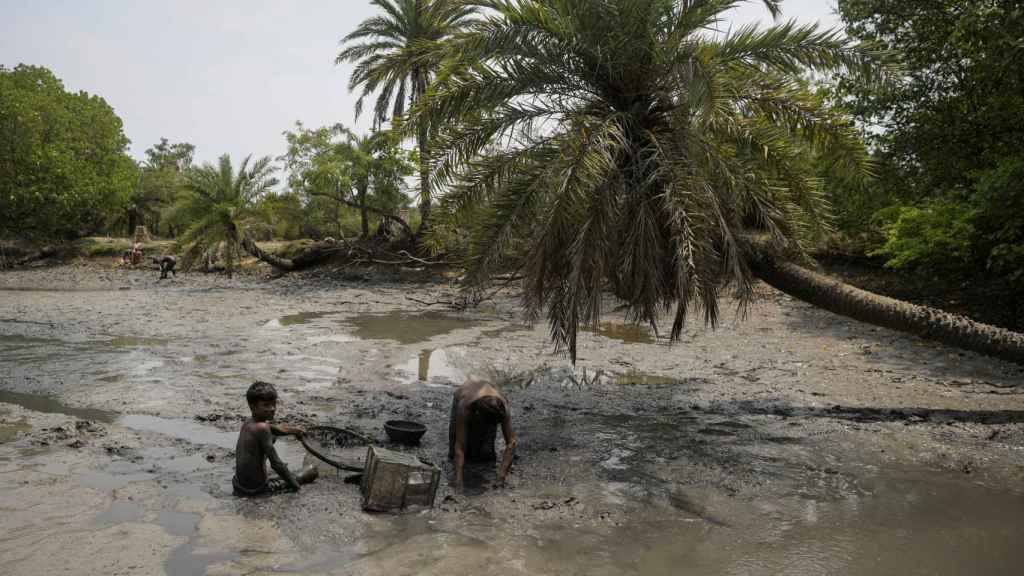 Niños buscando peces en el fango de la isla.