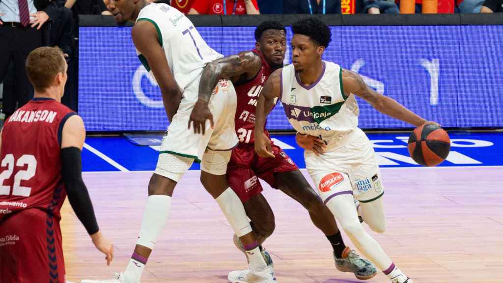 El base estadounidense de Unicaja Málaga Tyson Carter controla el balón ante la presión del base canadiense de UCAM Murcia Dylan Dennis