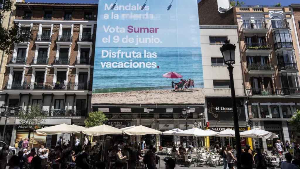 Sumar pide el voto para mandarles a la mierda con una gran lona en la calle Montera.
