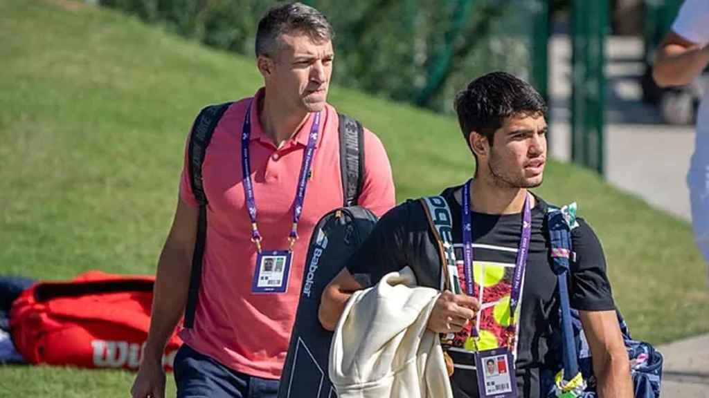 Juanjo López tras Carlos Alcaraz antes de un partido de Wimbledon.