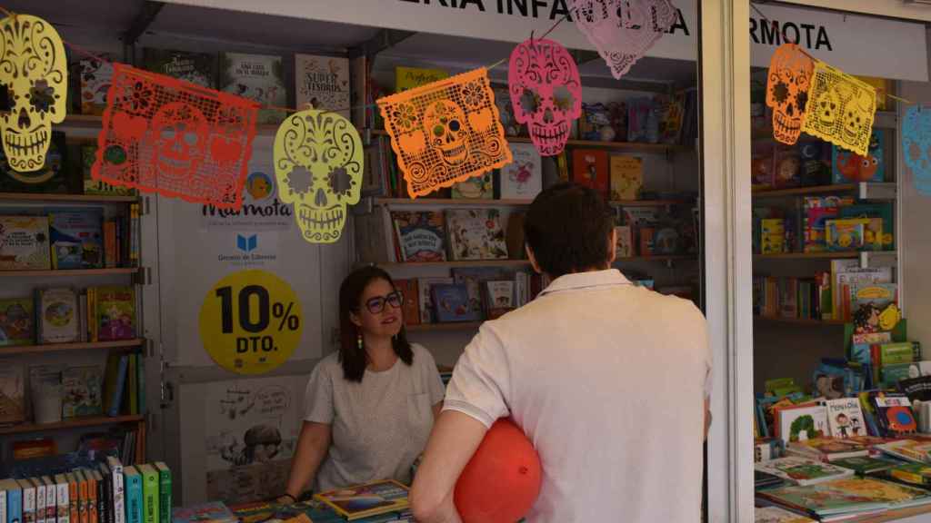Un visitante se para en el stand de una librería infantil