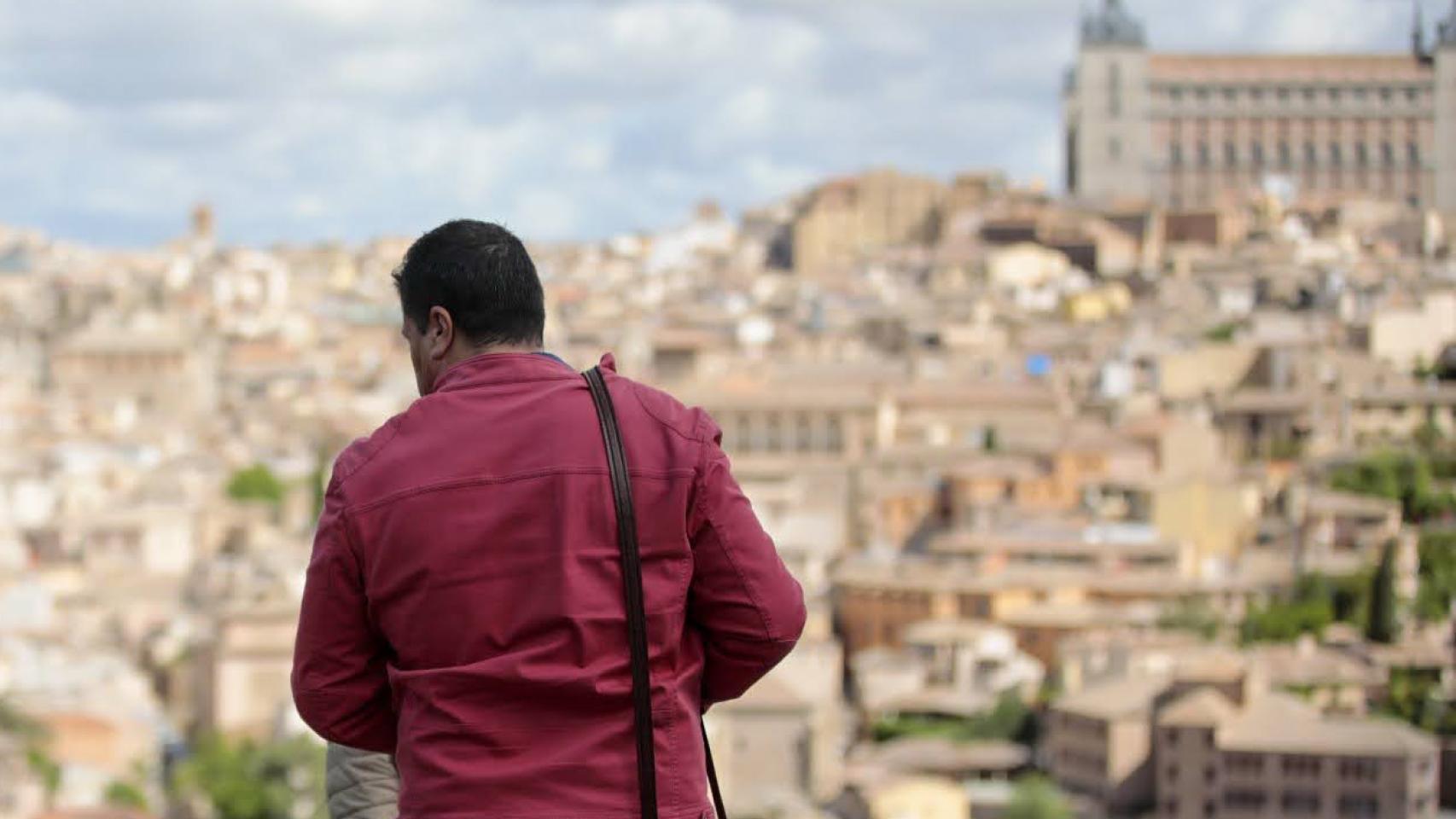 Dos turistas en las inmediaciones del Kiosco Base fotografían la panorámica de Toledo.