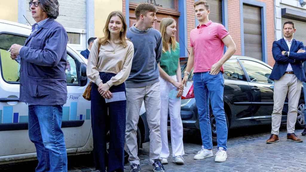 Los príncipes de Bélgica en la cola para entrar en su centro electoral.