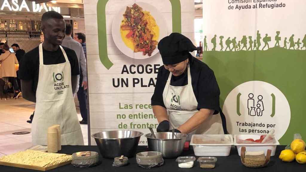 Patricia Vargas y Sane Mohamed, dos refugiados en Madrid participantes en la iniciativa 'Acoge un plato' durante el evento de presentación.