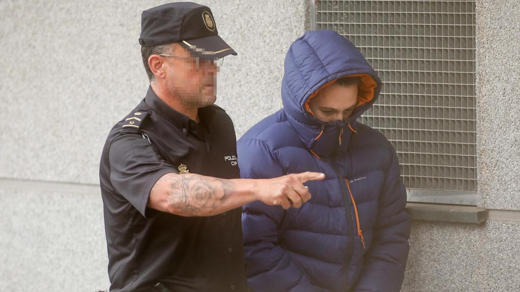 Guillermo Rodríguez a su entrada a los juzgados acompañado por un policía.