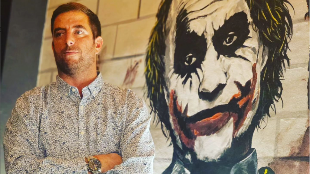 Sayo frente a un dibujo del Joker.