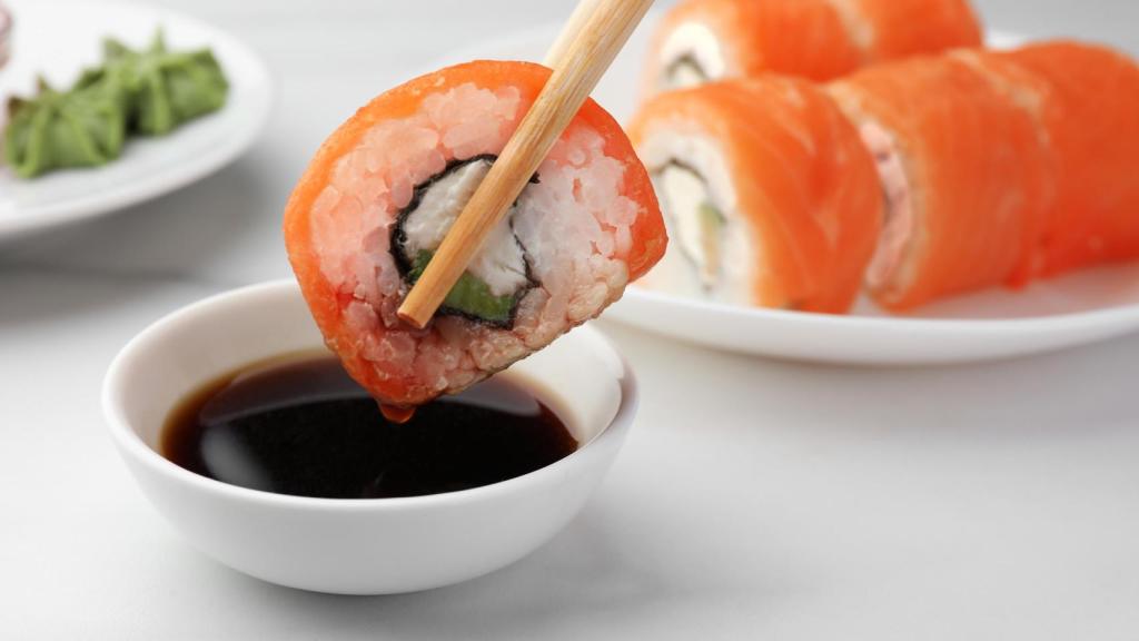Un maki se empapa en un cuenco de soja.